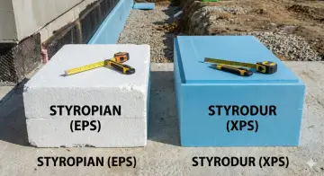 Biały styropian (EPS) i niebieski styrodur (XPS) leżą obok siebie. Narzędzia budowlane leżą na płytach.