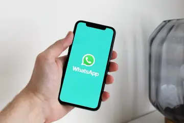 Dłoń trzyma smartfon z logo WhatsApp. Idealne narzędzie do komunikacji, gdy masz internet za granicą.
