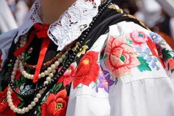 Piękny strój ludowy dla dziewczynki z haftowanymi kwiatami i koralami.