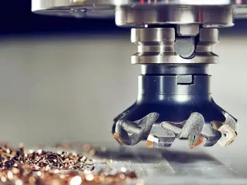 Głowica frezarska w akcji, precyzyjna obróbka CNC tworzy metalowe wióry.