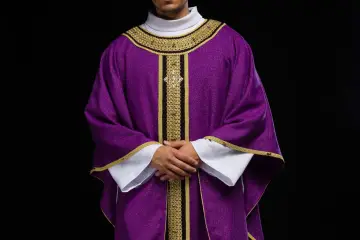 Kapłan w fioletowej szacie liturgicznej, symbolizującej kolor adwentu, z bogatymi złotymi zdobieniami.