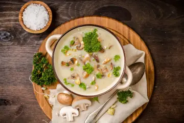 Kremowa zupa grzybowa z ziemniakami, udekorowana natką pietruszki. Zastanawiasz się, ile kalorii ma zupa grzybowa z ziemniakami?
