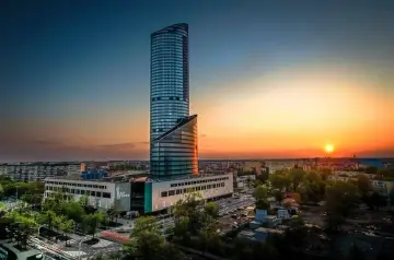 Sky Tower, imponujący wieżowiec, wznosi się ku niebu podczas zachodu słońca. Jego wysokość robi wrażenie.