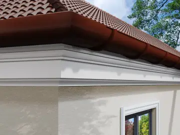Elegancki biały gzyms na elewacji domu, pod brązową rynną i dachówką.