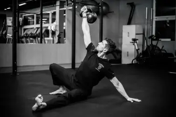 Mężczyzna wykonuje ćwiczenia na siłowni z kettlebell.