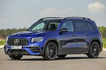 Niebieski Mercedes-AMG GLB 35 4MATIC na drodze. Wiele osób szuka mercedes glb opinie przed zakupem.