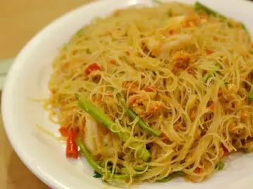 Pyszne danie z cienkim makaronem, przypominającym vermicelli czy capellini, z kawałkami krewetek i zielonych warzyw.