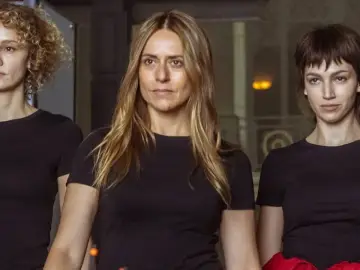 Trzy kobiety w czarnych koszulkach, część obsady "Dom z papieru", patrzą przed siebie.