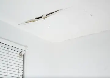 Widoczne pęknięcia na suficie w starym domu, świadczące o jego wieku i potrzebie remontu.