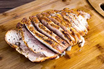 Pokrojony, pieczony schab z przyprawami, idealny do obiadu. Zastanawiasz się, jak długo piec schab, by był soczysty?