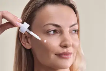 Kwas palmitynowy w kroplach serum pielęgnuje skórę kobiety, nadając jej blask.