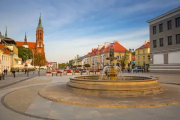 Fontanna na rynku w Białymstoku, stare miasto. W tle kościół i kamienice.