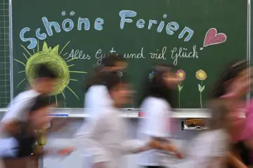 Schöne Ferien! Kinder freuen sich auf die Osterferien 2026 in NRW. Die Tafel zeigt Sonne, Blumen und ein Herz.