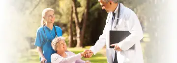 Lekarz i pielęgniarka opiekują się starszą panią na wózku. Geriatria co to? To troska o zdrowie seniorów.