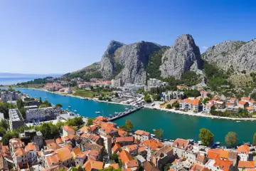 Widok na miasto Omiš w Chorwacji, z rzeką Cetiną i górami w tle. To malownicze lotnisko w Chorwacji jest idealnym miejscem na wakacje.