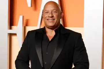 Vin Diesel, gwiazda "Szybcy i wściekli 11", uśmiecha się szeroko w czarnym smokingu.