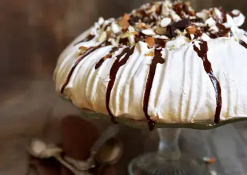 Pyszny tort bezowy z polewą czekoladową i migdałami. Zastanawiasz się, ile kosztuje tort bezowy w cukierni?