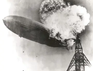 Płonący sterowiec Hindenburg eksploduje nad wieżą podczas lądowania.