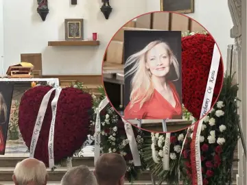 Katarzyna Stoparczyk i jej mąż, pogrążeni w żałobie, otoczeni wieńcami z czerwonych róż.