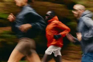 Trois coureurs en mouvement dans un décor forestier, suivant un programme reprise course à pied.