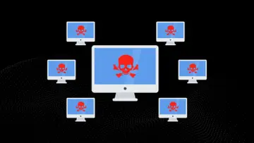 Komputery z czerwonymi czaszkami na ekranach, symbolizujące atak DDoS. To pokazuje, jak działa DDoS.