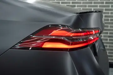 Przyciemnianie lamp tylnych w matowym, ciemnym samochodzie. Nowoczesne światła LED tworzą efektowny wzór.