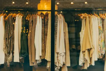 Vetrine di un negozio di abbigliamento con capi in tonalità neutre. Il **store manager** ha scelto un'esposizione elegante.