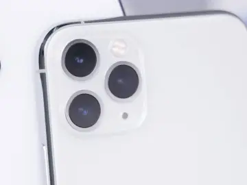 Biały telefon z potrójnym aparatem. Dowiedz się, jak wyczyścić telefon, aby był jak nowy.