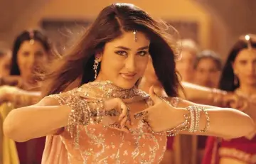Tancerka w bogato zdobionym stroju, z biżuterią i henną na dłoniach, w stylu bollywood.