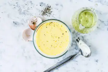 Zutaten für eine cremige french dressing: Eierschalen, Pfeffer, Öl und eine Schüssel mit der fertigen Soße.