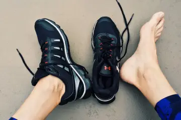 Stópkarz w czarnych butach sportowych z czerwonymi akcentami, gotowy do biegu.