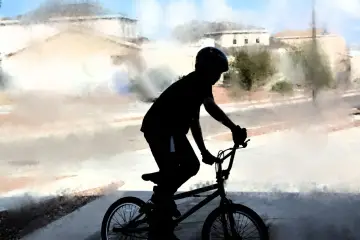 Chłopiec w kasku na rowerze BMX, gotowy na trening. Idealny posiłek przedtreningowy to energia do jazdy!