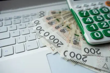 Kalkulator i banknoty 200 zł na klawiaturze. Obliczanie kwoty darowizny wolnej od podatku.