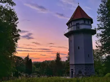 Wieża widokowa w Rynie, jedna z lokalnych atrakcji, na tle zachodzącego słońca.