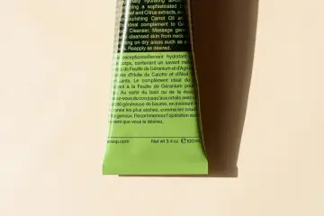 Zielony tubka z balsamem do ciała Aesop, z tekstem opisującym jego właściwości nawilżające i składniki, w tym ekstrakt z liści geranium.