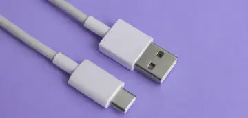 Biały kabel z wtyczkami USB-A i USB typu C na fioletowym tle.