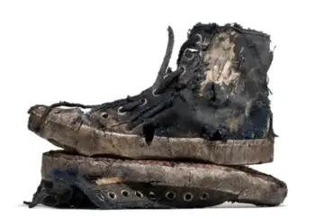 Un par de zapatillas gastadas, rotas y sucias, apiladas una sobre otra. Parecen haber vivido muchas aventuras.