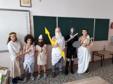 Dzieci w strojach bogów greckich: Zeus z piorunem, Hades w zbroi, Apollo z lirą. Świetny pomysł, jak przebrać dziecko za boga greckiego!