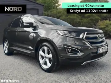 Ford Edge 2.0 TDCI w ciemnoszarym kolorze, zaparkowany przed garażem. Oferta leasingu i kredytu.