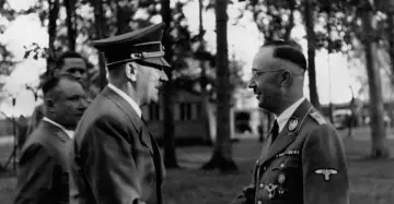 Hitler i Himmler rozmawiają na tle drzew. Na mundurze Himmlera widoczny symbol ss.