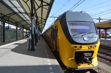 Żółty pociąg czeka na peronie. To mój pociąg do Holandii, gotowy do podróży.