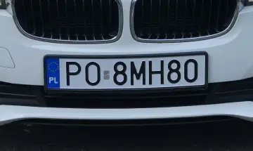 Białe auto z polską eku rejestracja PO 8MH80.