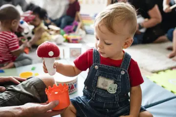 Mały chłopiec bawi się zabawkami w żłobku. To może być dobry moment, kiedy najlepiej dać dziecko do żłobka.