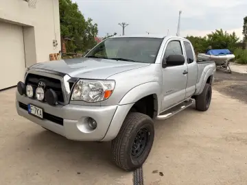 Srebrna Toyota Tacoma z dodatkowymi światłami, gotowa na przygodę.