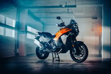 Pomarańczowo-czarny motocykl KTM z automatyczną skrzynią biegów, gotowy na przygodę.