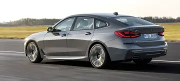 Szare BMW 6 GT pędzi po drodze, ukazując swoje eleganckie linie i sportowy charakter.
