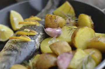 Pieczony seabass z ziemniakami, cytryną i czosnkiem.