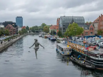 Bydgoszcz atrakcje na weekend: rzeźba "Przechodzący przez rzekę" na Brdzie, statki wycieczkowe i zabytkowa zabudowa.