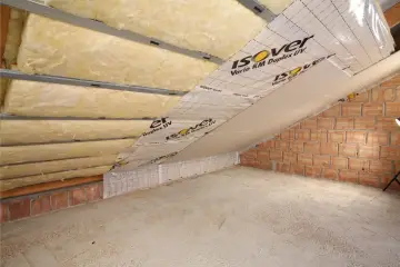 Montaż profili do płyt gipsowych na poddaszu, z widoczną wełną mineralną i paroizolacją.