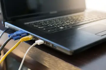 Kabel VGA i sieciowy podłączone do laptopa. Dowiedz się, jak podłączyć laptop z monitorem, aby rozszerzyć przestrzeń roboczą.